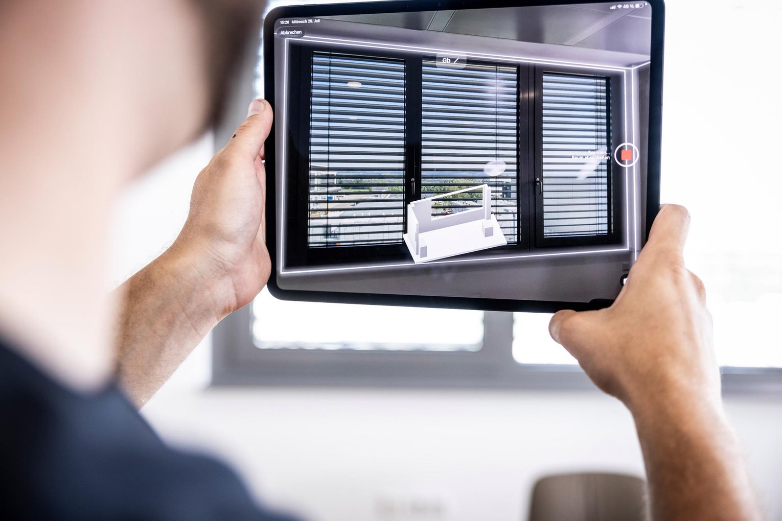 Person scannt mit der Tablet-Kamera ein Fenster mit Jalousien zur 3D-Raumerfassung