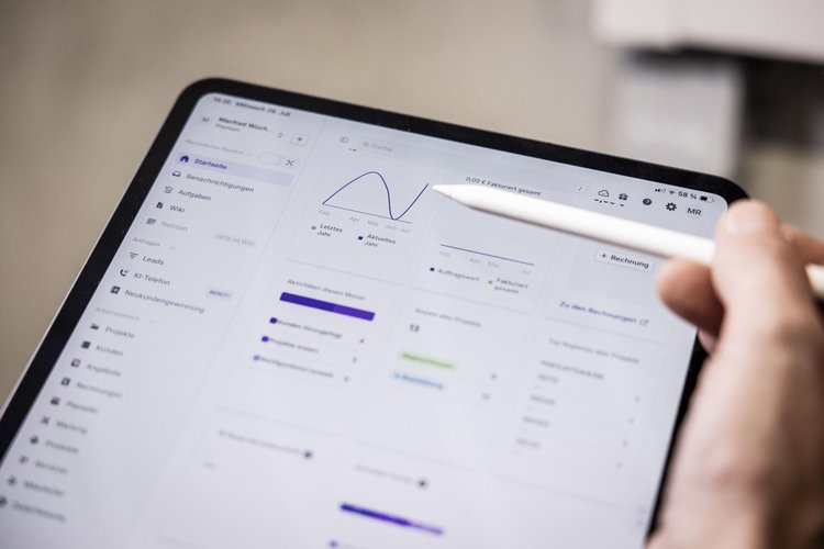 Heizungsbauer analysiert Heizlast eines Hauses am Tablet 